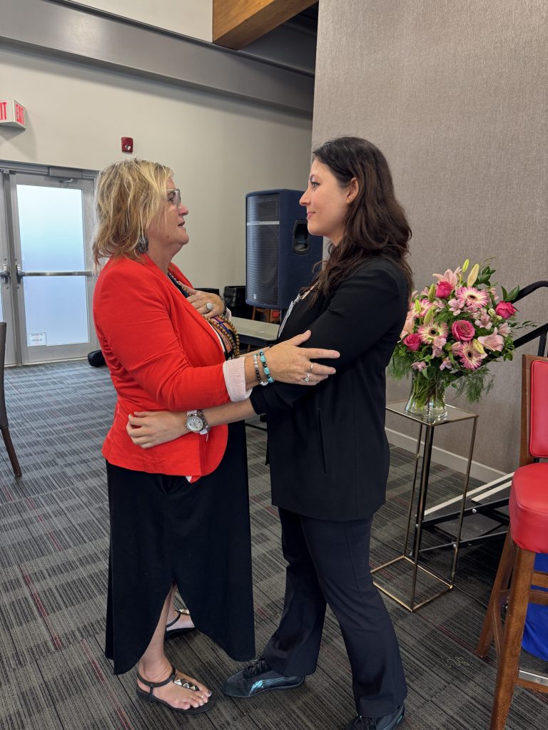 Positive interaction between two women at Clarington Business meeting.