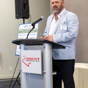 A man speaking at the Clarington Board of Trade annual business awards at Canadian Tire Motorsport Park, highlighting local business success.