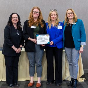 Group of women holding a recognition plaque at Clarington Board of Trade event.