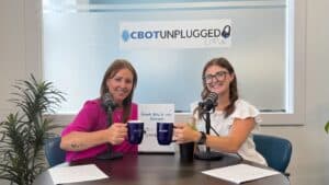 Close-up of two women clinking mugs during the Clarington Board of Trade podcast episode.