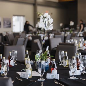 Event setup with floral centerpieces and tableware for business networking.