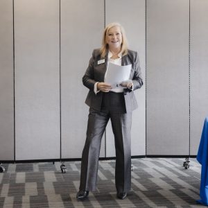 Businesswoman speaking at Clarington Board of Trade event in a conference room.