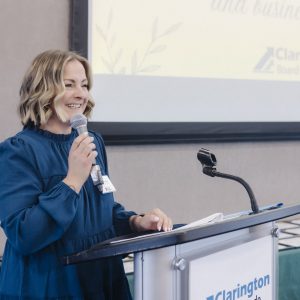 Woman speaking at Clarington Board of Trade event with microphone.