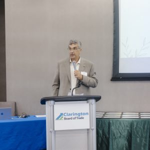 Man speaking at Clarington Board of Trade event with presentation screen.