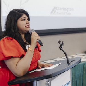 Woman speaking at Clarington Board of Trade event with microphone.