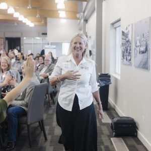Woman smiling at Clarington Board of Trade event, engaging with attendees.
