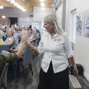 Woman shaking hands at Clarington Board of Trade event in a modern conference room.