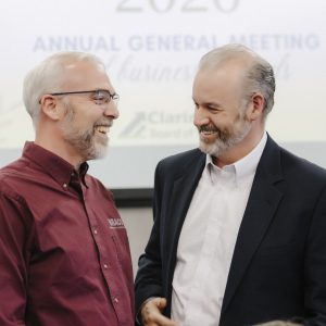 Two men smiling and talking at Clarington Board of Trade event.
