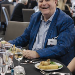 Man smiling at Clarington Board of Trade event with food and drinks.