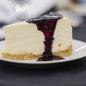 Cheesecake with berry topping on a white plate, served at Clarington Board of Trade event.