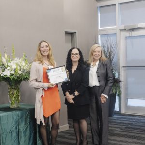 Three women at Clarington Board of Trade event, one holding an award.