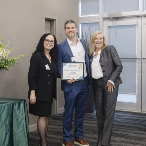 Clarington Board of Trade award recipient with two officials at event.