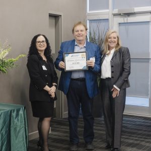 Three professionals at Clarington Board of Trade event, one holding an award certificate.