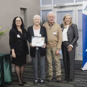 Group of four professionals at Clarington Board of Trade event, celebrating achievement.