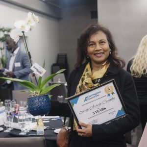 Award-winning woman holding certificate at Clarington Board of Trade event.